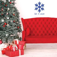 a red couch sitting next to a christmas tree