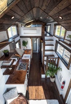 the interior of a tiny house with wood flooring and stairs leading up to the loft