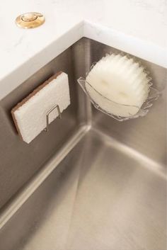 a close up of a sink with a sponge and soap dispenser in it