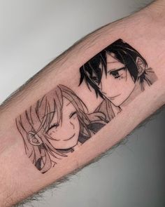 an arm with two anime characters on it and one is holding the other's head