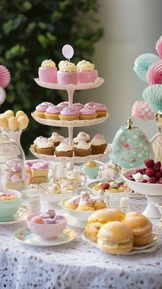 a table topped with lots of desserts and cupcakes on top of plates