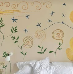 a white bed sitting under a painting on the wall