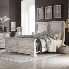 a white bed sitting in a bedroom next to a dresser and mirror on top of a hard wood floor