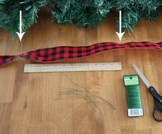 scissors and tape measure on the floor next to a christmas tree