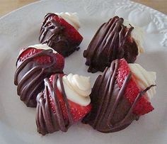 four chocolate covered strawberries on a white plate