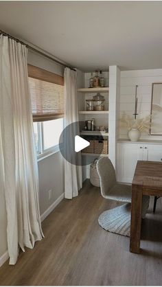 a living room filled with furniture next to a window covered in white curtains and drapes