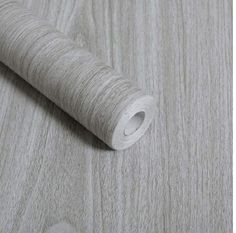 a roll of white woodgrain on top of a wooden floor with the end rolled up