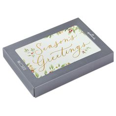 a boxed box with the words seasons greetings printed on it, sitting in front of a white background