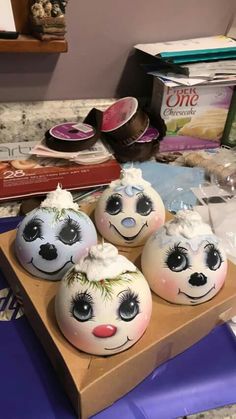 four painted eggs sitting on top of a cardboard box