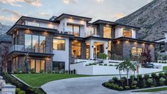 a large house with lots of windows on the front and side of it, surrounded by mountains