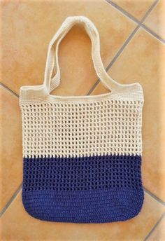 a blue and white crocheted bag sitting on top of a tile floor next to a tiled wall