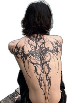 the back of a woman's body with black ink on it, sitting on a bench