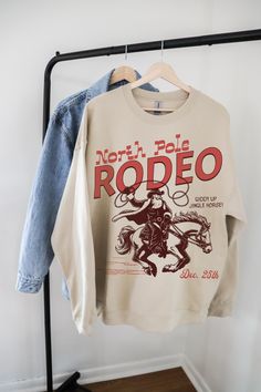 Get ready to jingle and yeehaw through the holidays with this fun and festive Western Christmas sweatshirt! Featuring a playful design of Santa riding a rearing horse, complete with the phrases "Up on the Rooftop" and "Yee Haw!" this cozy sweatshirt adds a quirky cowboy twist to holiday traditions. Perfect for Christmas parties, country-themed festivities, or anyone who loves a little humor with their holiday spirit, this sweatshirt makes a great gift for Western lovers and festive fashionistas Western Theme Christmas Party, Western Christmas Outfits Party, Rearing Horse, Cowboy Christmas, Cute Shirt Designs, Western Rodeo, Yee Haw, Western Christmas, Cow Girl