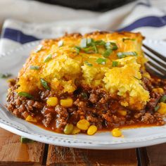 a close up of a plate of food with corn and meat casserole on it