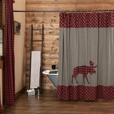 a bathroom with a moose shower curtain next to a bathtub and wooden wall behind it