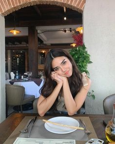 a woman sitting at a table in front of a plate with chopsticks on it