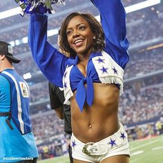 a cheerleader is holding her pom poms in the air at a football game