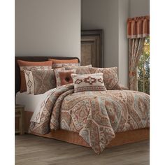 a bed in a room with a brown and orange comforter