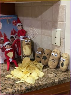 an elf is sitting on the counter next to some potato chips