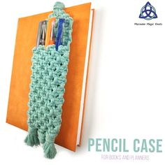 there is a crocheted book holder with pens and pencils in it on the wall