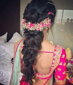 the back of a woman's head wearing a pink and gold bridal gown