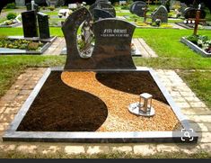 a cemetery with many headstones in the grass and dirt on the ground around them