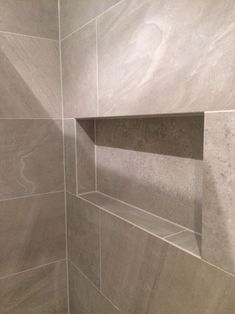 the corner of a tiled shower stall in a bathroom