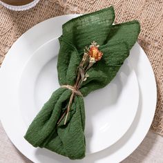 a white plate topped with green napkins and flowers