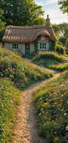 a path leading to a thatched roof cottage with flowers and trees in the foreground