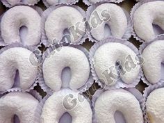 several donuts with white frosting are arranged in a row on a table top