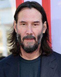 a man with long hair and beard wearing a suit