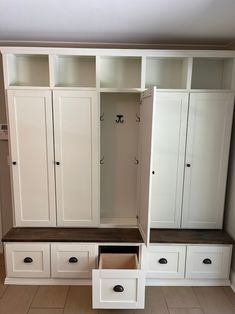 an empty room with white cabinets and drawers