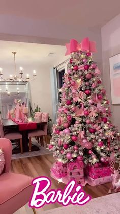 a pink christmas tree in a living room with the words barbie written on it's side