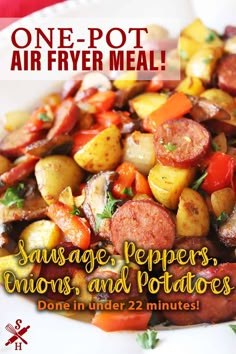 a white plate topped with sausage, peppers and potatoes