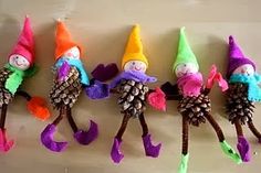 four little gnomes with pine cones on their heads are lined up next to a sign that says pink and green mama