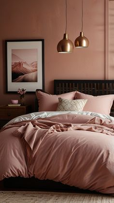 a bed with pink sheets and pillows in a bedroom next to two hanging light fixtures