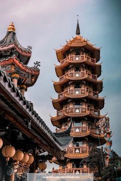 a tall tower with lots of windows next to other buildings in front of the sky