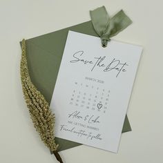 a save the date card on top of an envelope with a dried plant next to it