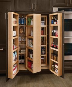 an open cabinet in the middle of a kitchen