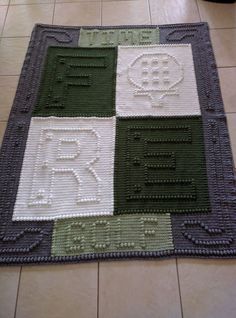 a green and white rug on the floor in a room with tile floors that have different colored squares