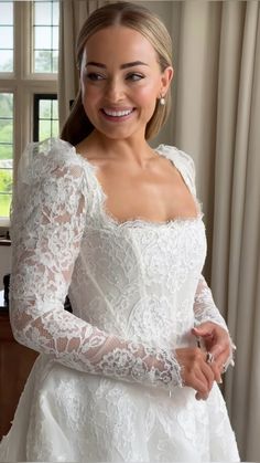 a woman in a white wedding dress smiling at the camera