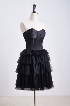 This dress features a corset bodice and a tiered ruffle skirt, with a sweetheart neck and zip-up back. Made from black tulle, it has an A-line silhouette and falls above the knee. Item #NP1112 Material: Tulle Color: Black Silhouette: A-line Embellishment: Corset bodice, tiered ruffle skirt Neck: Sweetheart neck Back: Zip-up Length: Above knee length Fully lined: Yes Built-in bra: Yes True to size. Made in China. Dresses are usually packed inside out for protection. Hand wash Tiered Ruffle Skirt, Corset Bodice, Homecoming Dresses Black, Short Homecoming Dress, Black Tulle, Black Silhouette, Ruffle Shorts, Sweetheart Neck, Ruffle Skirt