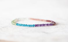 This colorful, delicate bracelet is made up of micro faceted gemstone rondelles - garnet, sunstone, lemon quartz, peridot, neon blue apatite and amethyst. All gemstones are natural and untreated. These lovely little beads have perfect facets and lots of sparkle.... this is a sweet bit of rainbow to wear around your wrist. The bracelet is completed with a small bead in your choice of sterling silver, gold filled or rose gold filled, which covers and protects the knot in the elastic. This bracelet Spiritual Multicolor Faceted Beaded Bracelets, Multi Wrap Bracelet, Purple Jewelry, Rainbow Bracelet, Blue Apatite, Lemon Quartz, Neon Blue, Faceted Gemstones, Birthstone Jewelry