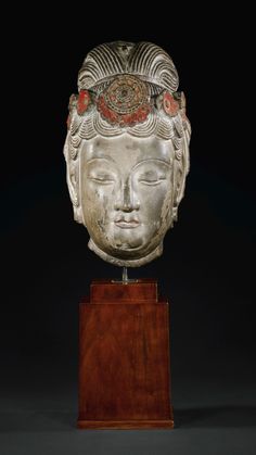 a white head on top of a wooden stand in front of a black background with red accents