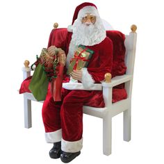 a santa clause sitting in a chair holding a christmas present and looking at the camera