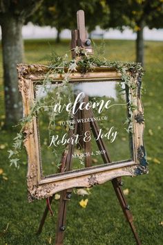 an easel with greenery on it and a sign that says welcome to the wedding