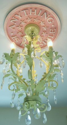 a chandelier hanging from the ceiling in a room with pink and white walls