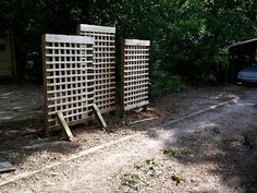 a car parked in front of a wooden fence next to a forest filled with trees