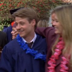 a man in a graduation cap and gown is being congratulated by two other people