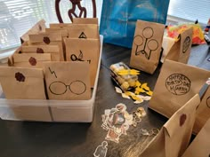 some brown paper bags are sitting on a table with stickers and other items around them